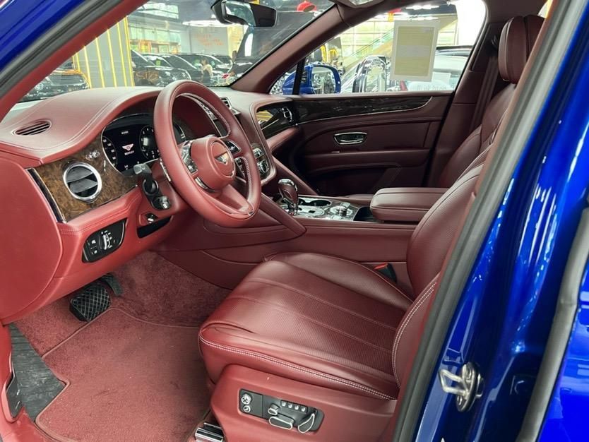 22款宾利添越内饰整体采用真皮进行包裹,并辅以木纹饰板和部分镀铬